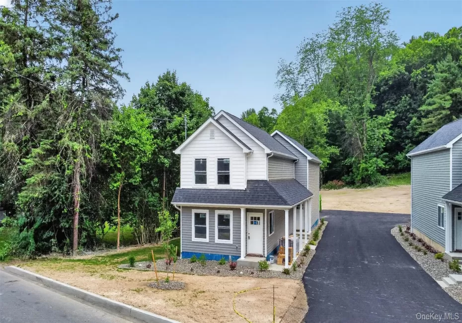 Modern two-story residence featuring light gray and white siding, a dark shingle roof, and a welcoming covered porch Modern two-story residence featuring light gray and white siding, a dark shingle roof, and a welcoming covered porch