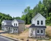 Newly constructed two-story residence featuring a covered front porch, white trim, and a dark shingle roof Newly constructed two-story residence featuring a covered front porch, white trim, and a dark shingle roof