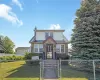 Stone and siding facade featuring a gabled roofline, front porch entry, and mature evergreen landscaping Stone and siding facade featuring a gabled roofline, front porch entry, and mature evergreen landscaping