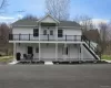 View of front facade with a shingled roof and stairway View of front facade with a shingled roof and stairway