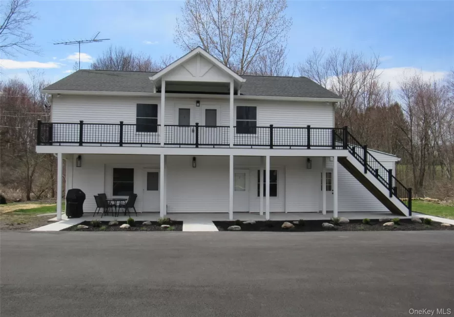 View of front facade with a shingled roof and stairway View of front facade with a shingled roof and stairway
