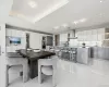 Dining room with light tile patterned floors, a raised ceiling, and recessed lighting Dining room with light tile patterned floors, a raised ceiling, and recessed lighting