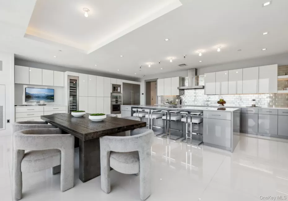 Dining room with light tile patterned floors, a raised ceiling, and recessed lighting Dining room with light tile patterned floors, a raised ceiling, and recessed lighting