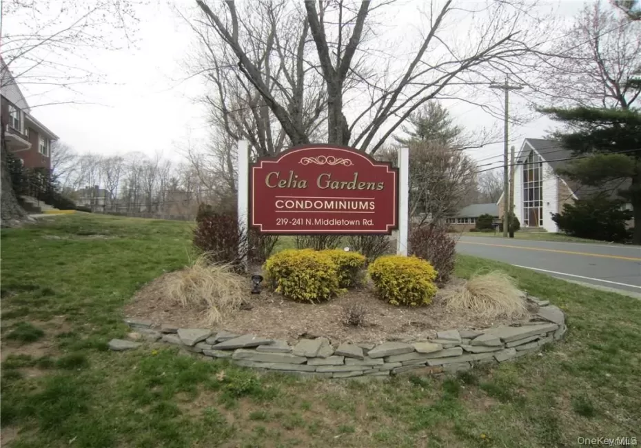 Community sign featuring a lawn Community sign featuring a lawn