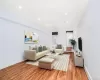 Living room with wood finished floors, recessed lighting, and radiator heating unit Living room with wood finished floors, recessed lighting, and radiator heating unit