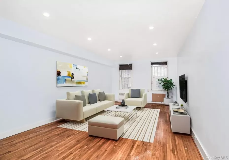 Living room with wood finished floors, recessed lighting, and radiator heating unit Living room with wood finished floors, recessed lighting, and radiator heating unit