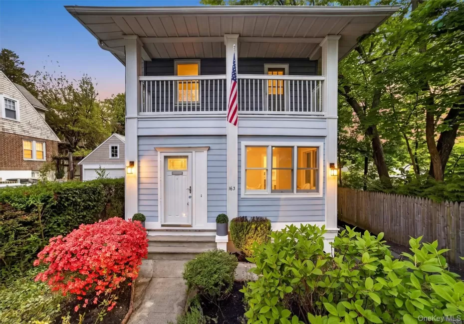 Two-story facade featuring light blue horizontal siding and a white front door with transom window Two-story facade featuring light blue horizontal siding and a white front door with transom window