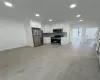 open living space Modern kitchen featuring white cabinetry, stainless steel appliances, and a light-toned countertop with matching backsplash open living space Modern kitchen featuring white cabinetry, stainless steel appliances, and a light-toned countertop with matching backsplash