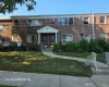 Two-story brick facade building featuring multiple windows, a covered entryway, and a concrete walkway Two-story brick facade building featuring multiple windows, a covered entryway, and a concrete walkway