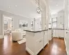 Gourmet kitchen with white shaker cabinetry, stainless steel appliances, dark countertops, and wood-finish flooring Gourmet kitchen with white shaker cabinetry, stainless steel appliances, dark countertops, and wood-finish flooring