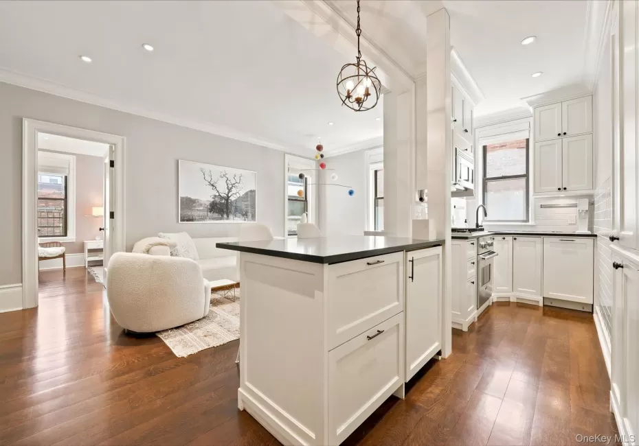 Gourmet kitchen with white shaker cabinetry, stainless steel appliances, dark countertops, and wood-finish flooring Gourmet kitchen with white shaker cabinetry, stainless steel appliances, dark countertops, and wood-finish flooring