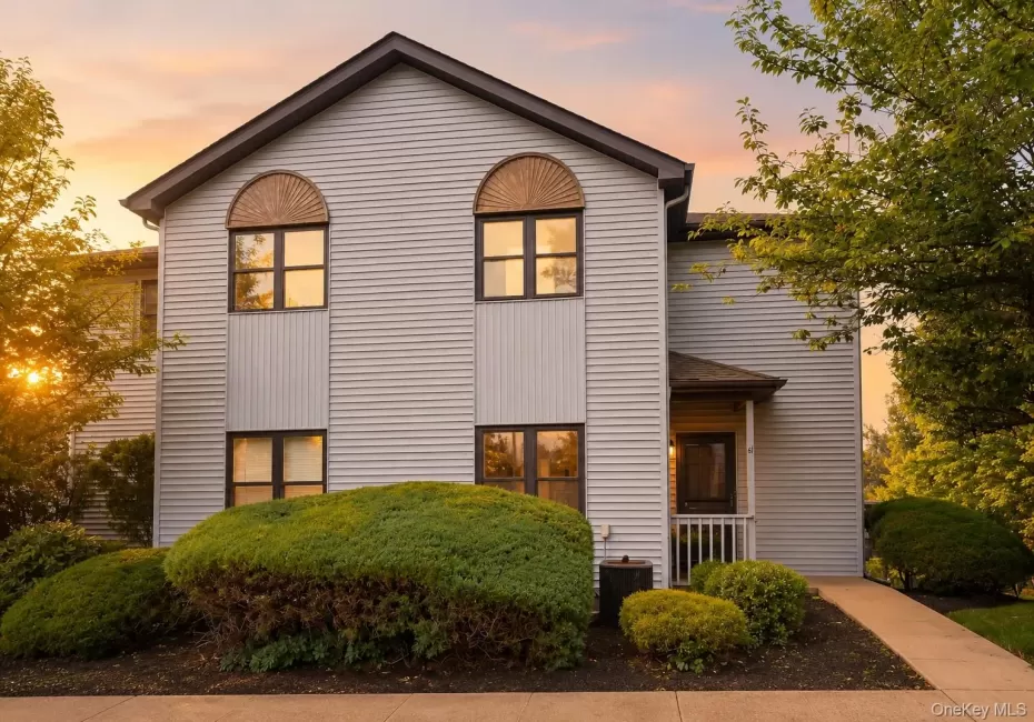 Two-story residence featuring light-colored horizontal siding and a dark-toned roof Two-story residence featuring light-colored horizontal siding and a dark-toned roof