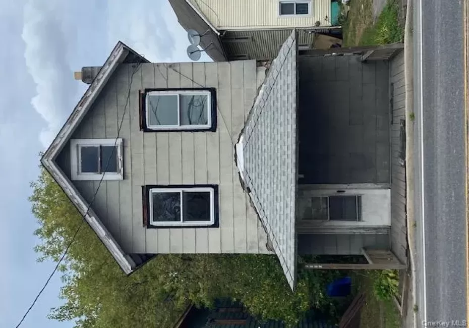 View of front of house with a chimney, a deck, and roof with shingles View of front of house with a chimney, a deck, and roof with shingles