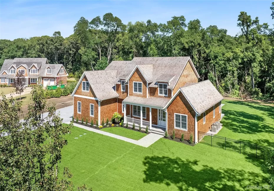 Shingle-style home featuring a porch and roof with shingles Shingle-style home featuring a porch and roof with shingles