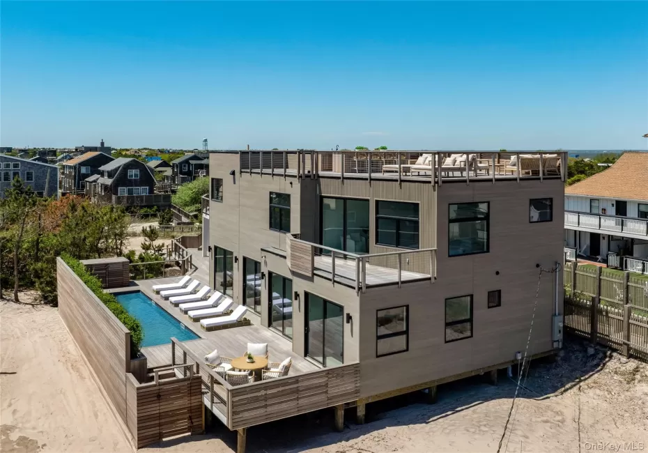 Rear view of property with a wooden deck, a residential view, and an outdoor pool Rear view of property with a wooden deck, a residential view, and an outdoor pool