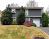 View of front of property with an attached garage, a front lawn, and driveway View of front of property with an attached garage, a front lawn, and driveway