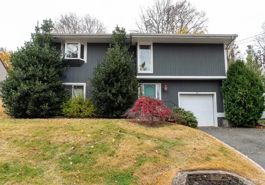 View of front of property with an attached garage, a front lawn, and driveway View of front of property with an attached garage, a front lawn, and driveway
