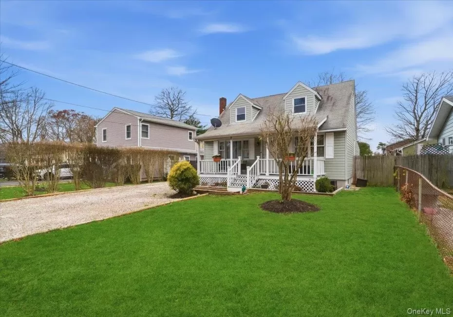 New england style home featuring a porch, a chimney, driveway, and roof with shingles New england style home featuring a porch, a chimney, driveway, and roof with shingles