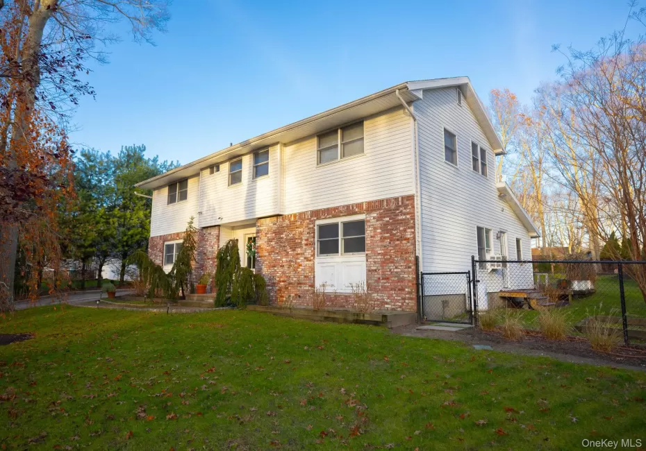 Rear view of property featuring a gate and brick siding Rear view of property featuring a gate and brick siding