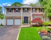 Large Colonial residence featuring a prominent front entrance with an ornate dark wood door Large Colonial residence featuring a prominent front entrance with an ornate dark wood door