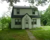 Two-story residence featuring white siding and a dark roof Two-story residence featuring white siding and a dark roof