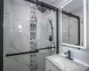 Bathroom featuring vanity and a marble finish shower Bathroom featuring vanity and a marble finish shower