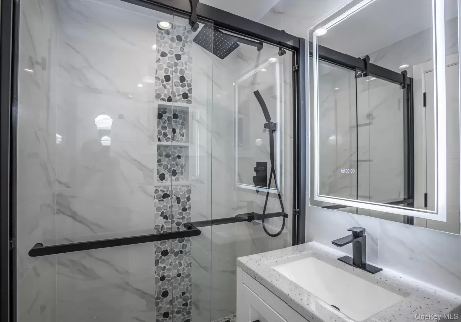 Bathroom featuring vanity and a marble finish shower Bathroom featuring vanity and a marble finish shower