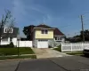 View of front of home with stone siding, a garage, driveway, a gate, and a chimney View of front of home with stone siding, a garage, driveway, a gate, and a chimney