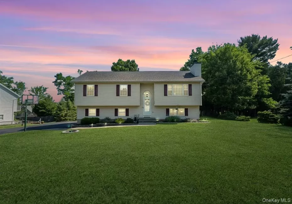 Bi-level residence featuring a light-toned exterior with dark shutters and a central entry Bi-level residence featuring a light-toned exterior with dark shutters and a central entry