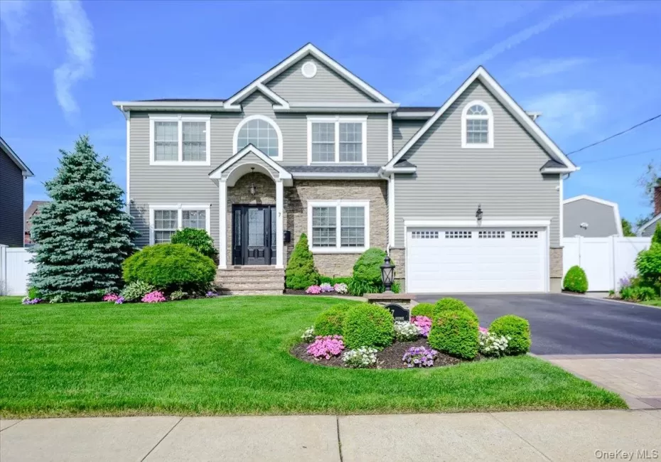Gray siding exterior with stone accents, a prominent arched window, a two-car garage. Gray siding exterior with stone accents, a prominent arched window, a two-car garage.