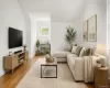 Living area featuring wood-finish flooring, white walls, and a prominent window Living area featuring wood-finish flooring, white walls, and a prominent window
