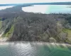 Aerial view of property's location featuring a nearby body of water and a heavily wooded area Aerial view of property's location featuring a nearby body of water and a heavily wooded area