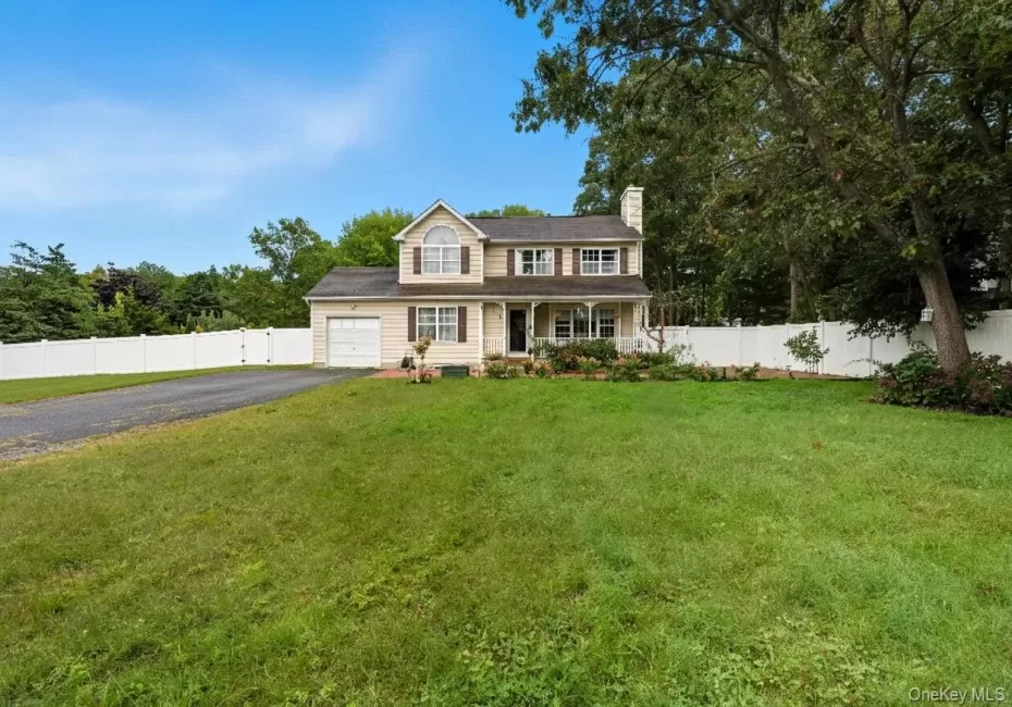 View of front of house with covered porch, driveway, a chimney, and view of scattered trees View of front of house with covered porch, driveway, a chimney, and view of scattered trees