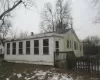 Snow covered property featuring a wooden deck and a chimney Snow covered property featuring a wooden deck and a chimney