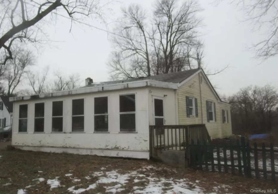 Snow covered property featuring a wooden deck and a chimney Snow covered property featuring a wooden deck and a chimney
