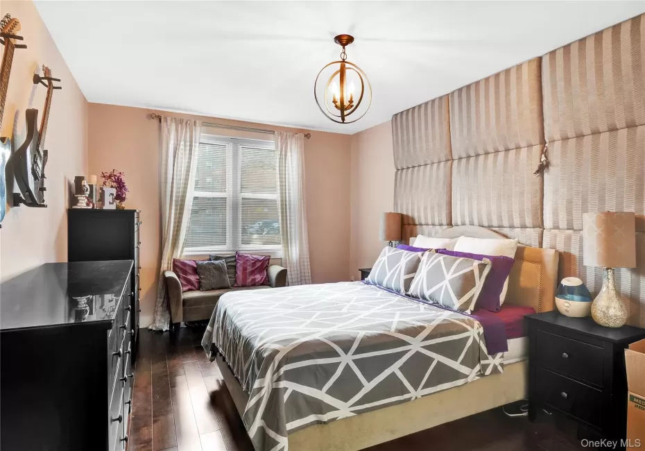 Bedroom featuring dark wood-type flooring and a chandelier Bedroom featuring dark wood-type flooring and a chandelier