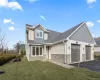 View of front facade with roof with shingles, stone siding, an attached garage, asphalt driveway, and a front lawn View of front facade with roof with shingles, stone siding, an attached garage, asphalt driveway, and a front lawn
