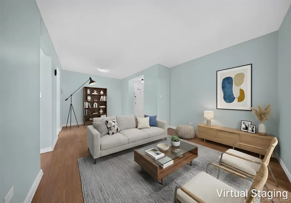 Spacious living area featuring light blue walls and wood-finish flooring Spacious living area featuring light blue walls and wood-finish flooring