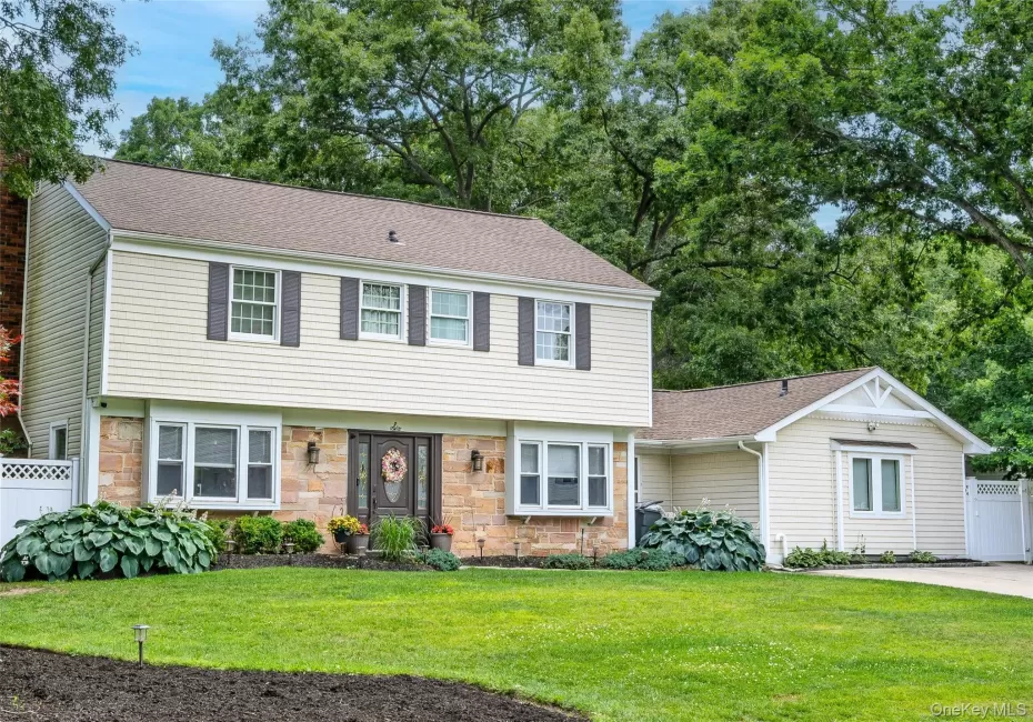 Two-story exterior with light-colored siding and stone-finish facade Two-story exterior with light-colored siding and stone-finish facade