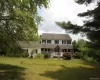 Two-story residence featuring white siding and dark shutters Two-story residence featuring white siding and dark shutters