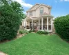 Stucco exterior with a columned porch featuring a ceiling fan and wrought iron railing Stucco exterior with a columned porch featuring a ceiling fan and wrought iron railing