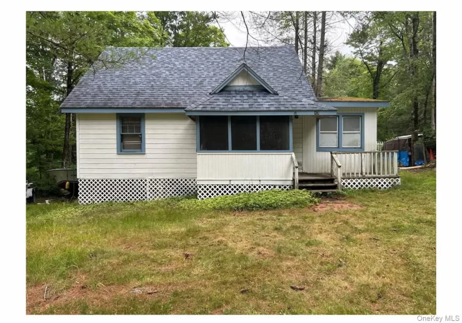 View of front of house featuring a shingled roof, a deck, a sunroom, and a front yard View of front of house featuring a shingled roof, a deck, a sunroom, and a front yard