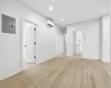 Unfurnished living room with electric panel, light wood-style floors, and recessed lighting Unfurnished living room with electric panel, light wood-style floors, and recessed lighting