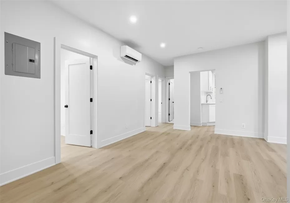 Unfurnished living room with electric panel, light wood-style floors, and recessed lighting Unfurnished living room with electric panel, light wood-style floors, and recessed lighting