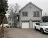 Traditional-style house featuring stucco siding, concrete driveway, an attached garage, and a shingled roof Traditional-style house featuring stucco siding, concrete driveway, an attached garage, and a shingled roof