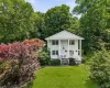 Two-story residence featuring a classic white facade, columned porch, and multiple windows Two-story residence featuring a classic white facade, columned porch, and multiple windows