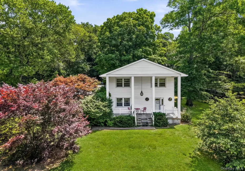 Two-story residence featuring a classic white facade, columned porch, and multiple windows Two-story residence featuring a classic white facade, columned porch, and multiple windows