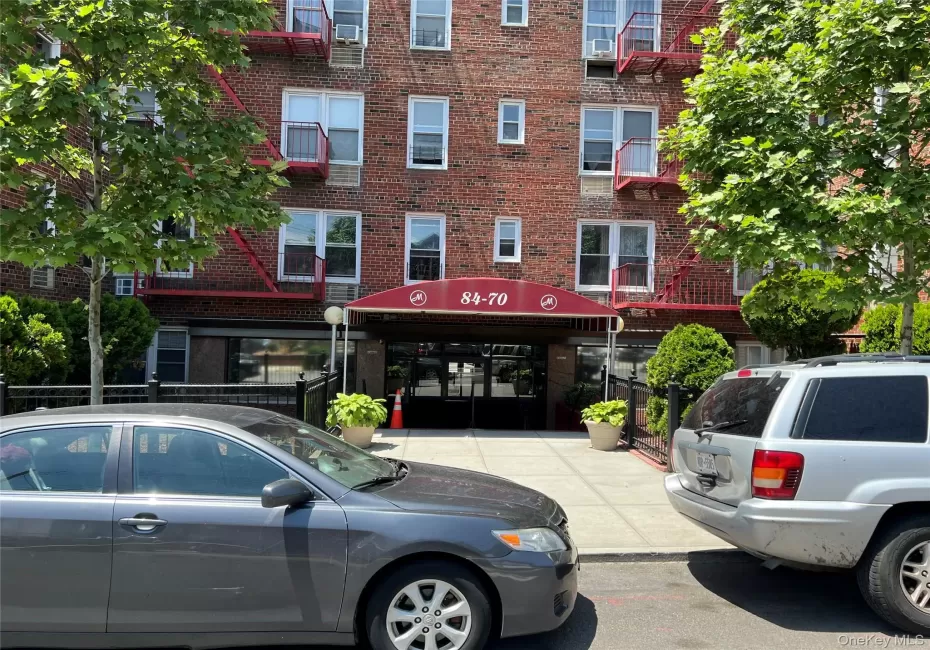 Brick facade building with a prominent red entrance awning Brick facade building with a prominent red entrance awning