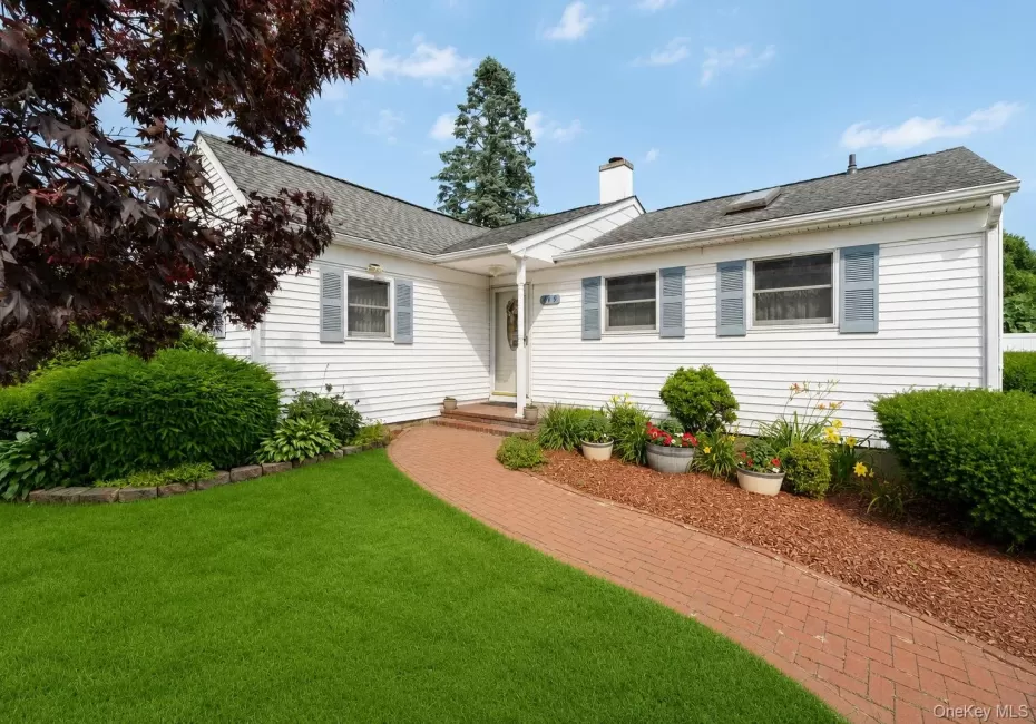 White siding exterior with a dark shingle roof, complemented by light blue louvered shutters White siding exterior with a dark shingle roof, complemented by light blue louvered shutters