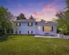 White siding residence featuring a prominent front lawn and a concrete patio White siding residence featuring a prominent front lawn and a concrete patio